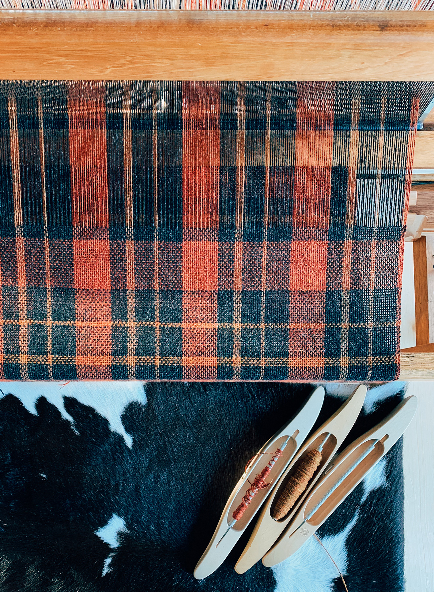 a top down view of the fireside check deisgn being woven on a floor loom.